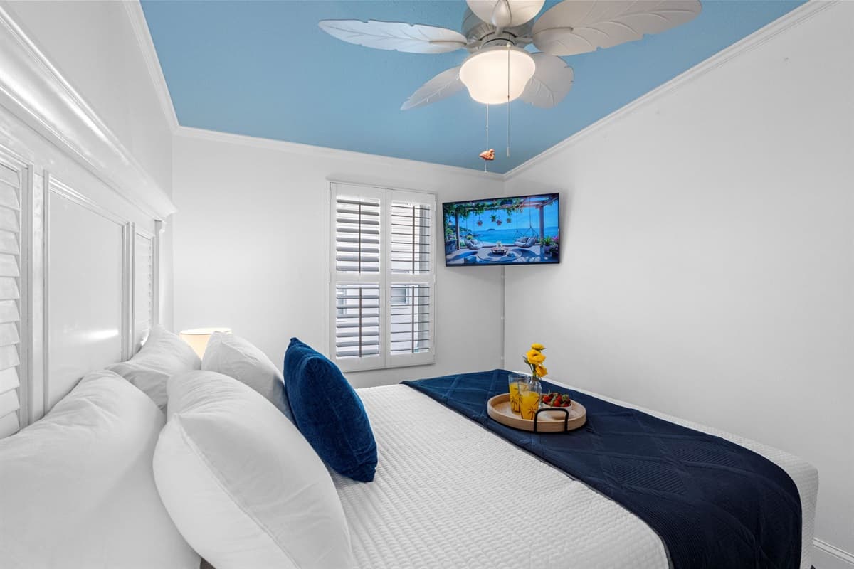 A soothing coastal palette and sky-blue ceiling create a relaxing atmosphere perfect for unwinding.