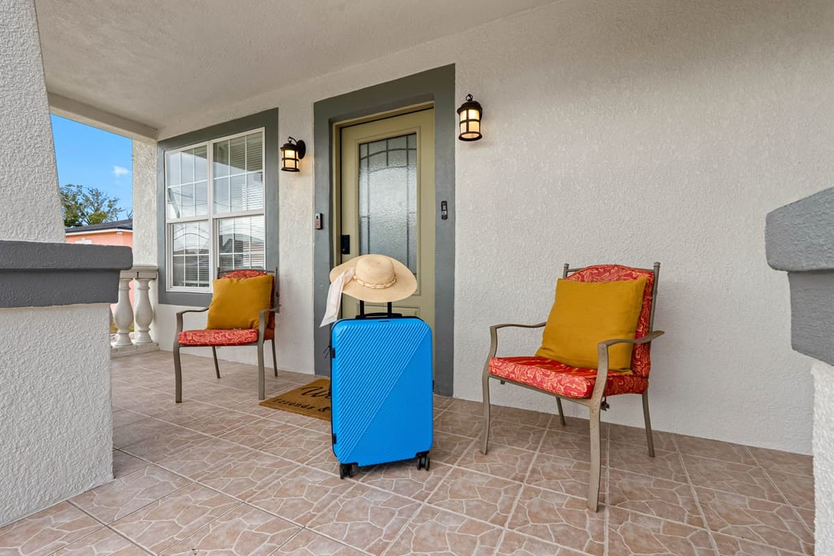 This well-lit front porch provides a welcoming entrance with stylish seating, making check-in feel effortless and setting the tone for a comfortable stay.