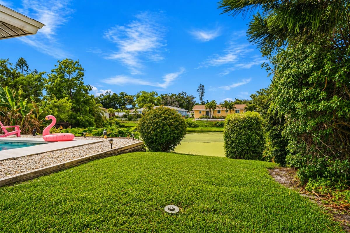 Private backyard oasis with manicured lawn and easy access to the pool area.