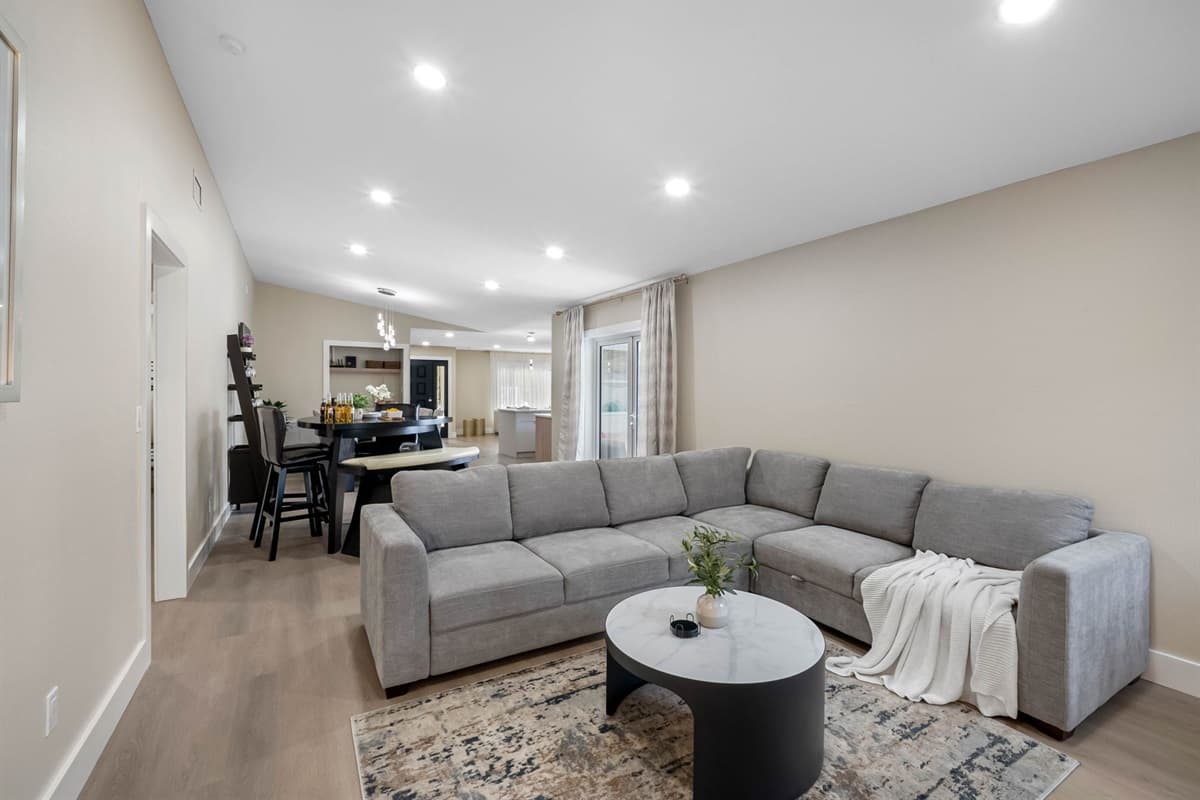 Enjoy cozy evenings in this family room featuring a large sectional sofa, a sleek coffee table, and soft lighting. The neutral palette and minimalist décor make it the perfect space to relax after a day of exploring.