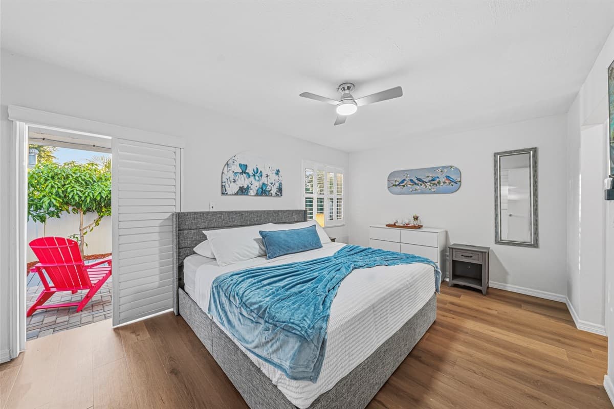 Cozy bedroom with king bed, bright natural light, and direct access to outdoor seating 