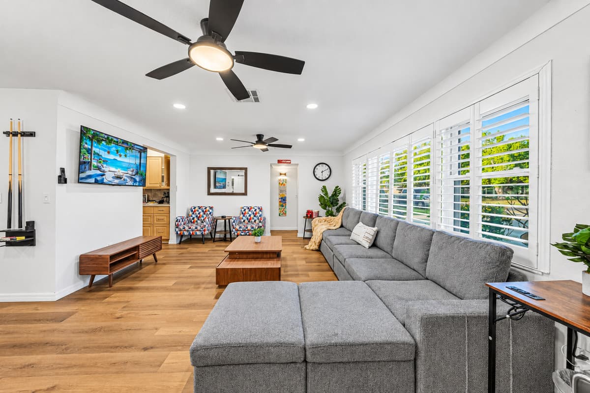 Bright and spacious living room with comfortable seating and smart TV—ideal for relaxing together 