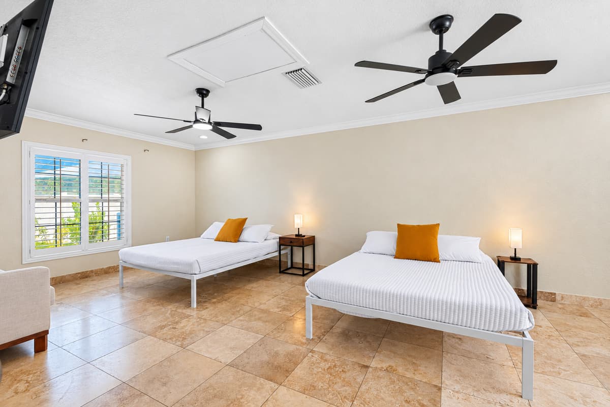 This inviting space features two plush queen-sized beds, each outfitted with soft, hotel-quality linens, cozy comforters, and an abundance of pillows to ensure a restful night’s sleep for every guest.