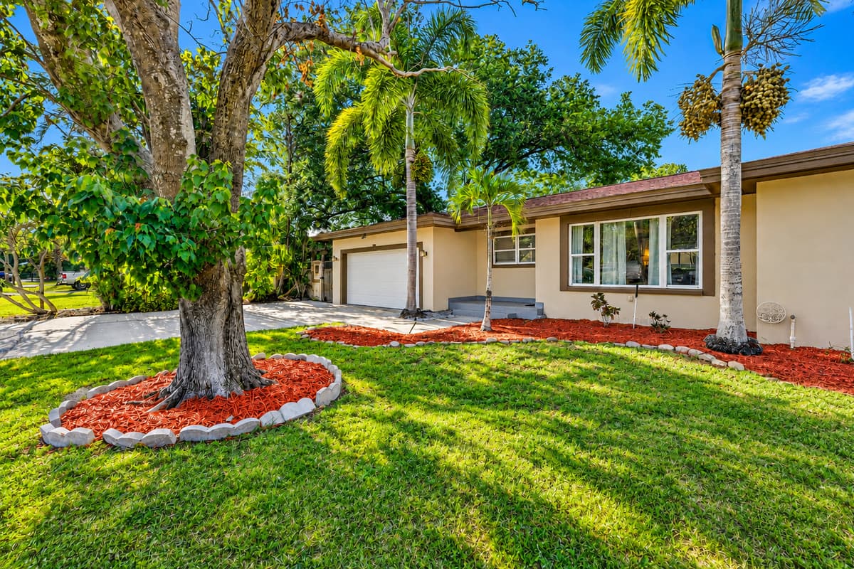 Charming front yard with mature trees, manicured lawn, and inviting curb appeal.