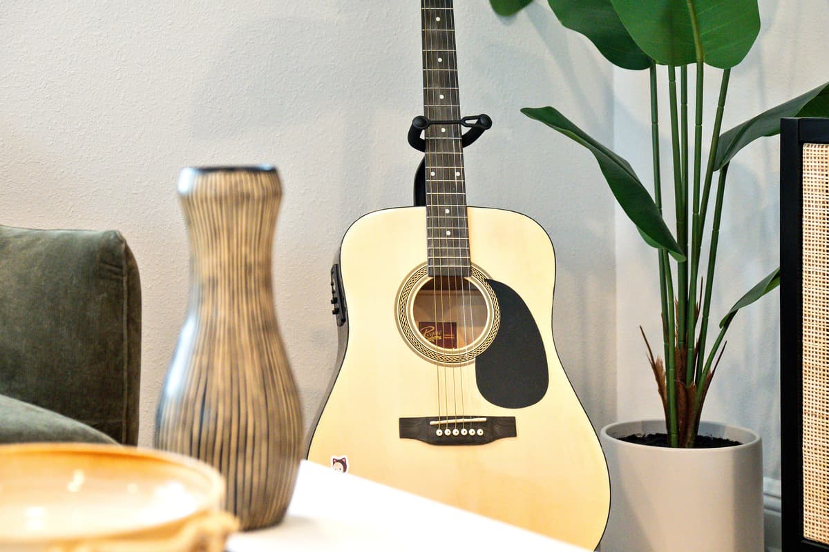 A guitar stands proudly in one corner, its sleek silhouette inviting you to strum a few chords and lose yourself in the magic of music.