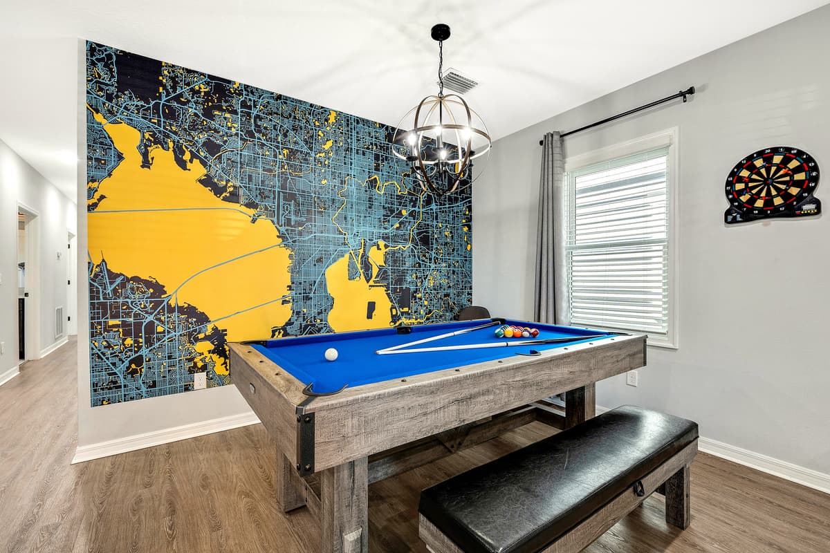 At the heart of the game room stands the centerpiece - a convertible pool table seamlessly transformed into a ping pong table.