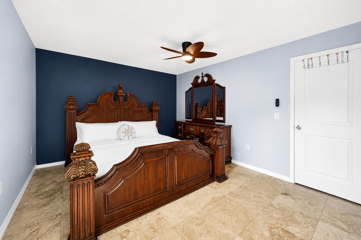 Relax in the spacious primary suite featuring a king-size bed, stylish furnishings, and a peaceful atmosphere.