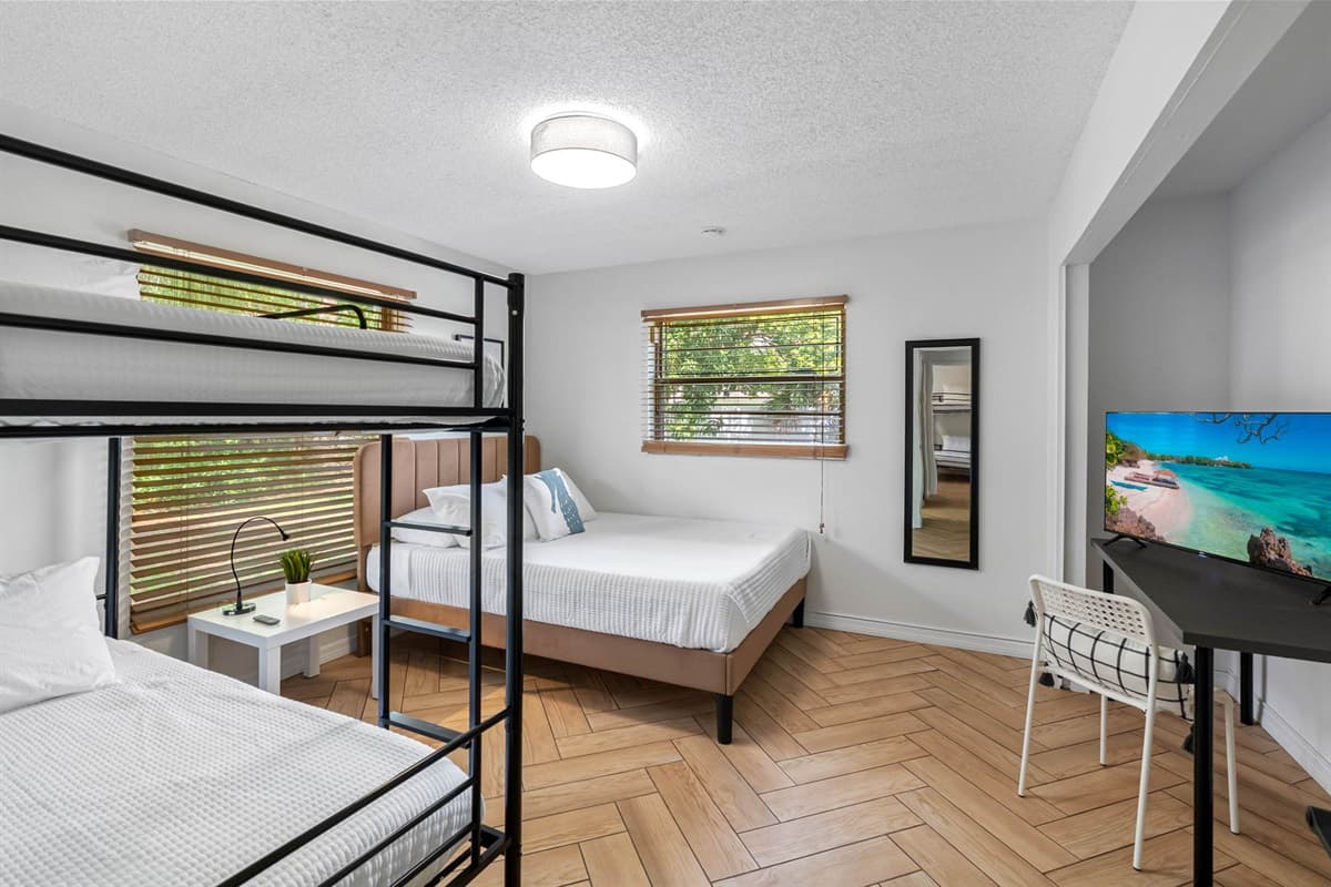 Decorated with light tones and beachy charm, this bedroom offers a queen-size bed plus a bunk bed, creating the perfect mix of playfulness and peace.