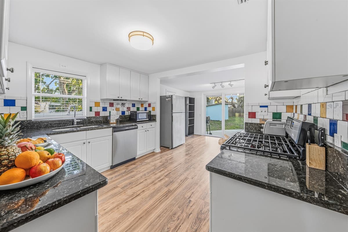 Spacious kitchen with central cooking area and easy access to dining and patio.