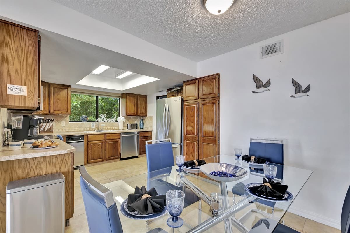 The dining area features a sleek and modern glass table that comfortably accommodates up to four people.