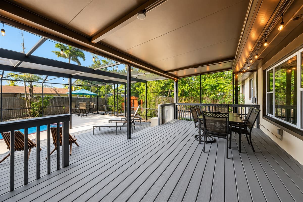Beautiful screened patio with outdoor dining, pool views, and cozy evening lighting.