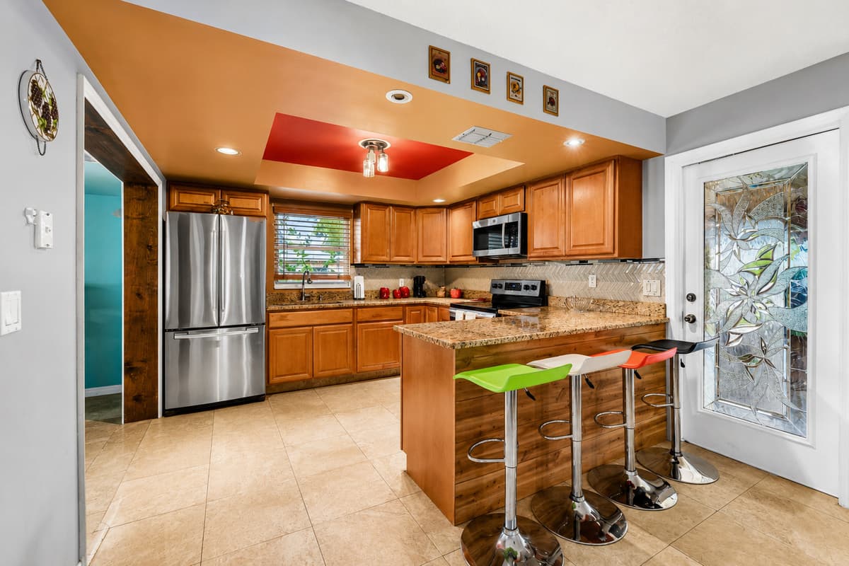 Features stainless steel appliances, granite countertops, and a breakfast bar with seating.