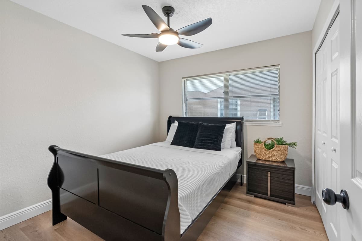 At the center of the room is a striking dark wood sleigh bed, offering a timeless and elegant silhouette.