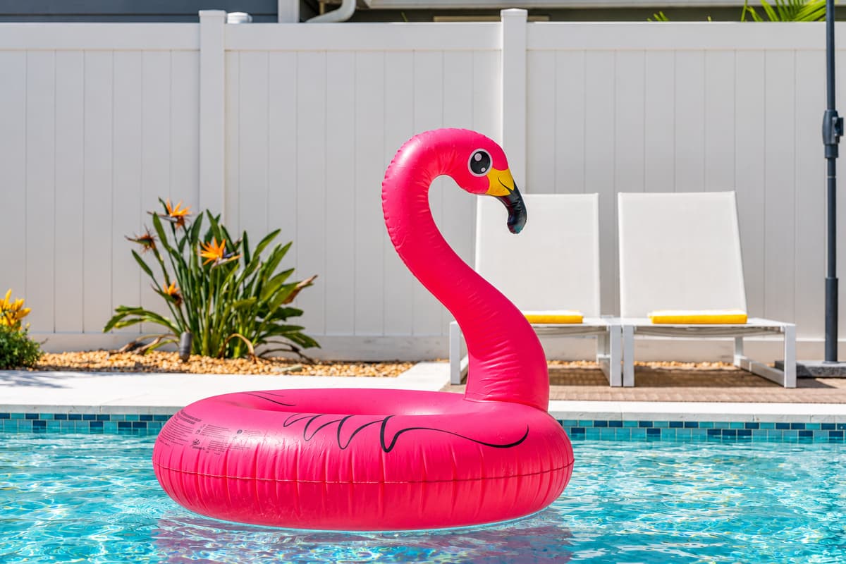 The pool’s clean lines and calming color palette are matched only by its playful flamingo float and inviting seating areas.