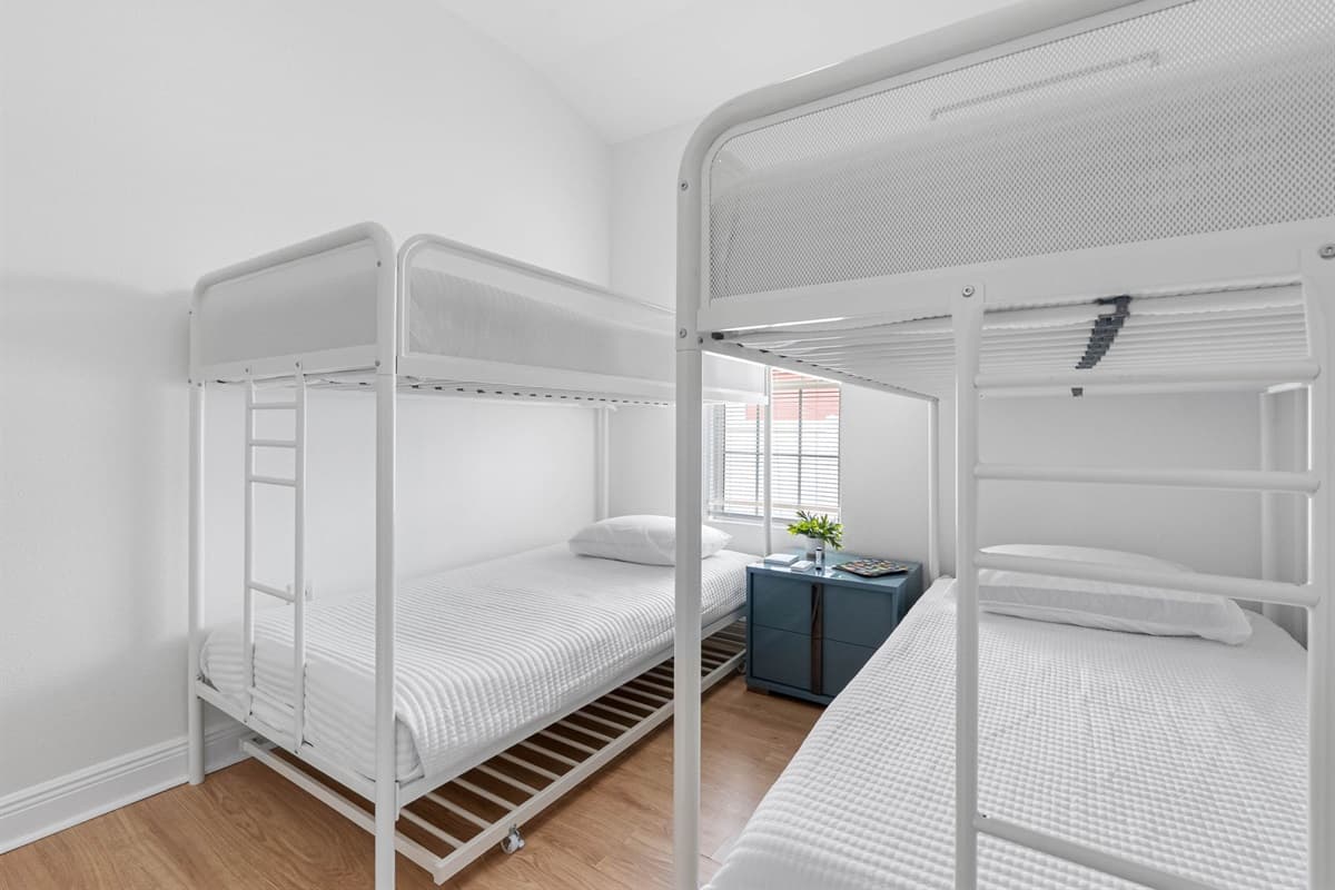 Bright and thoughtfully designed, this bunk bedroom features two modern twin-over-twin bunk beds, making it ideal for kids or groups. Clean lines, soft bedding, and natural light create a comfortable and welcoming space.