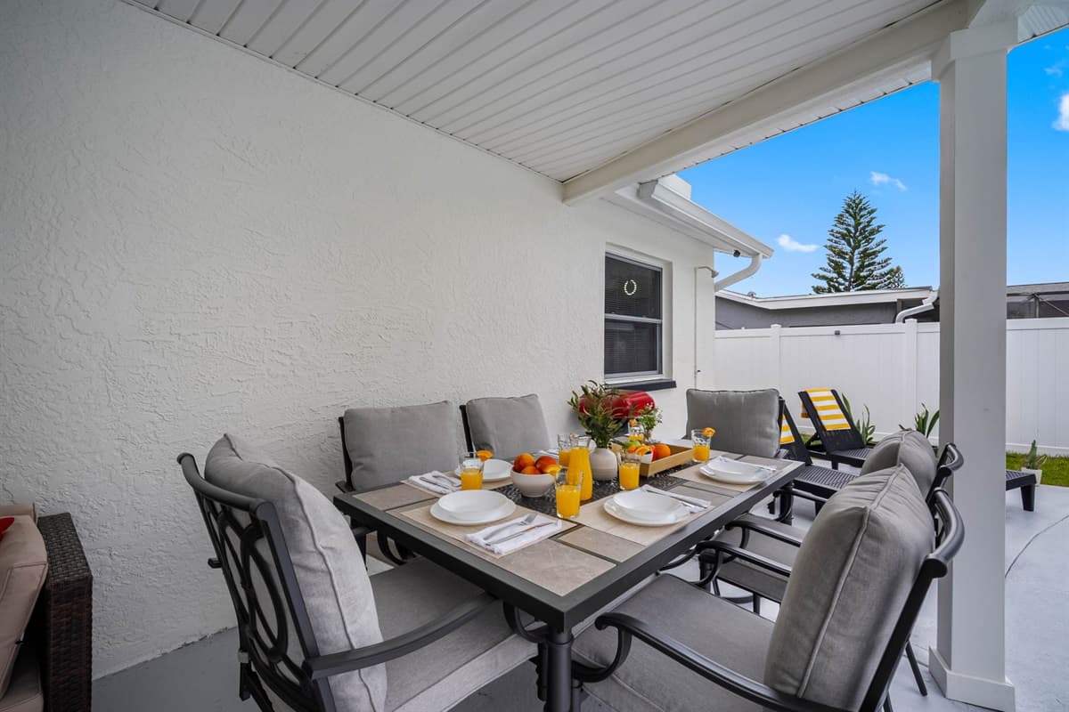 Enjoy outdoor dining in style with this beautifully set patio space. Featuring a comfortable dining table, cozy seating, and a view of the pool, it’s perfect for morning coffee or evening gatherings.