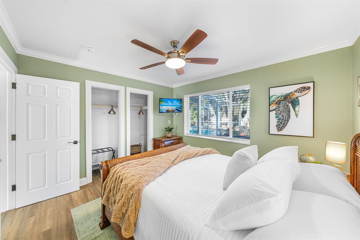 A serene queen bedroom with soft lighting, comfortable furnishings, and a cozy atmosphere.