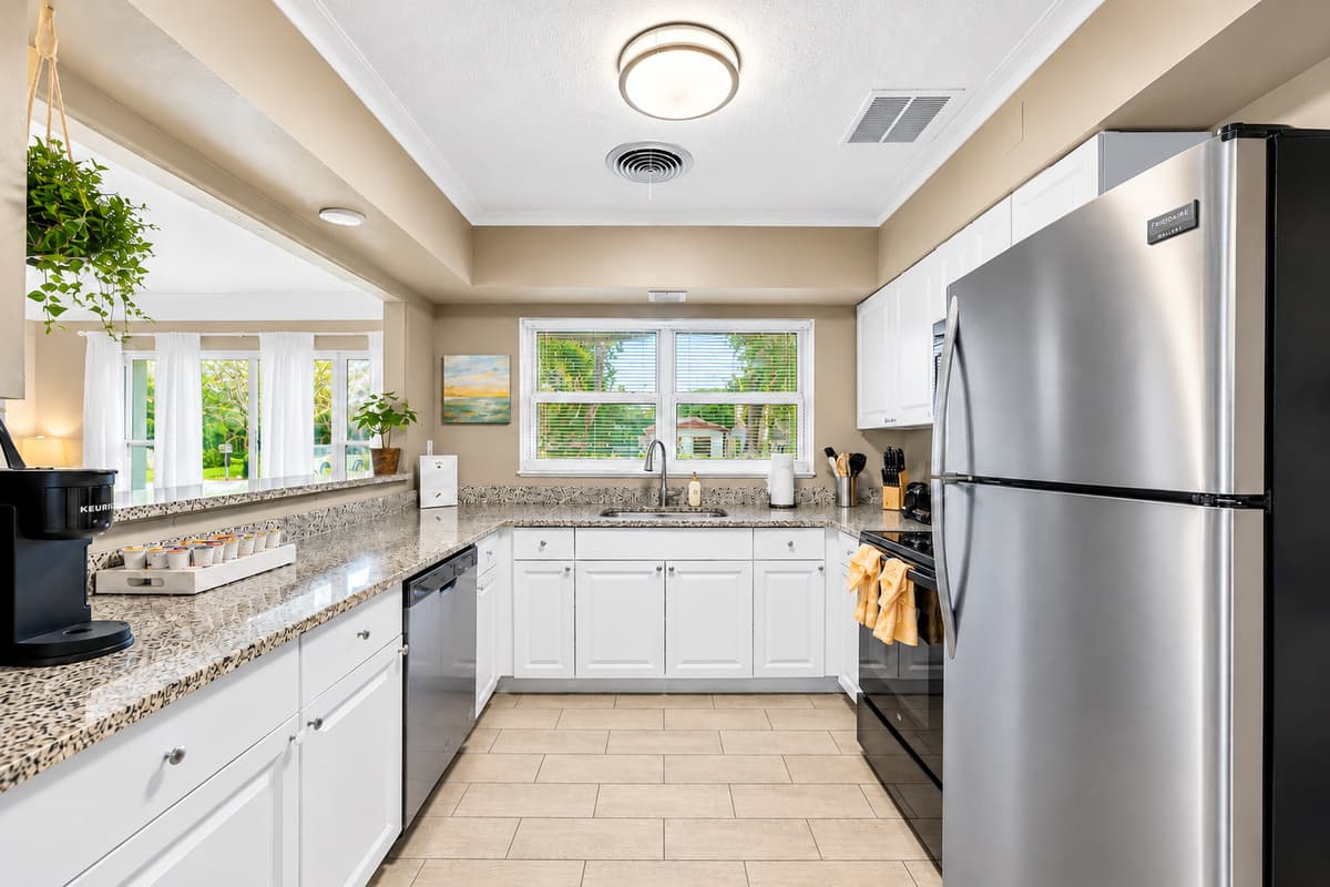 Fully equipped kitchen with stainless steel appliances and an open, airy layout.