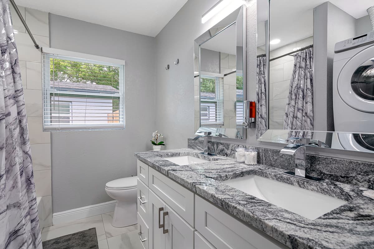 This stunning bathroom has a bathtub, shower, toilet and his and hers sink. It is also equipped with full sized washer and dryer. If you have any questions, send us a message!