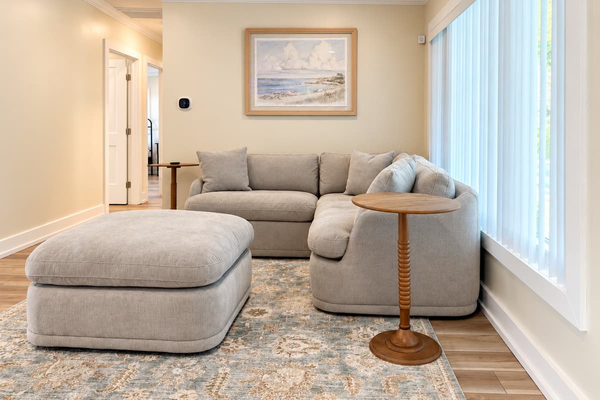 Front living room with sectional seating, TV and fireplace feature.