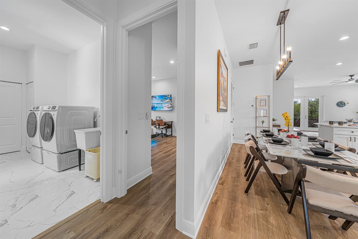Hallway view connecting dining area and laundry space, showcasing convenient layout and in-home washer and dryer.