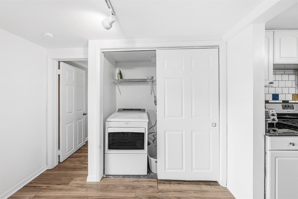 Bright laundry area with washer/dryer setup and storage space.