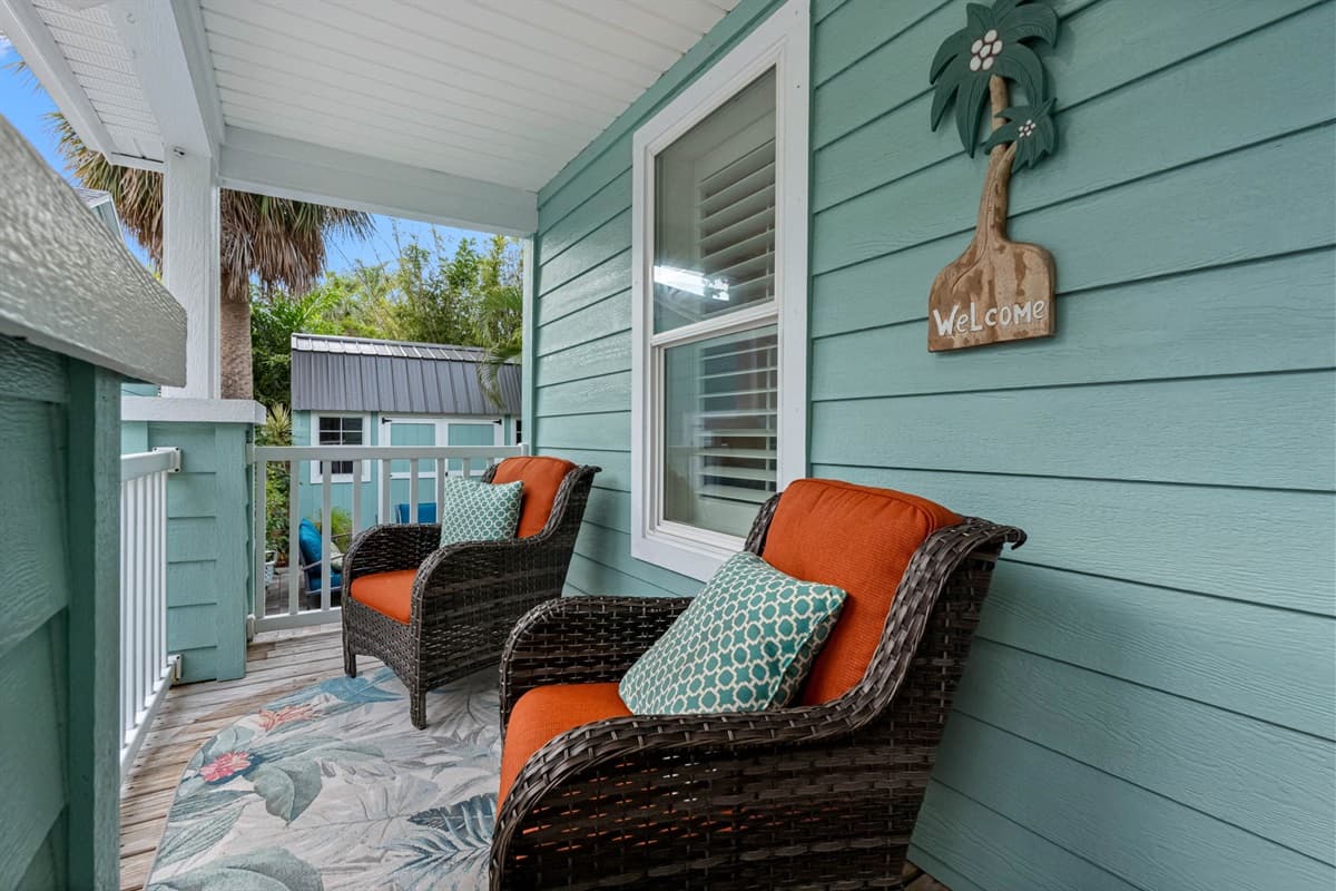 The inviting front porch features a cozy seating area perfect for enjoying your morning coffee.