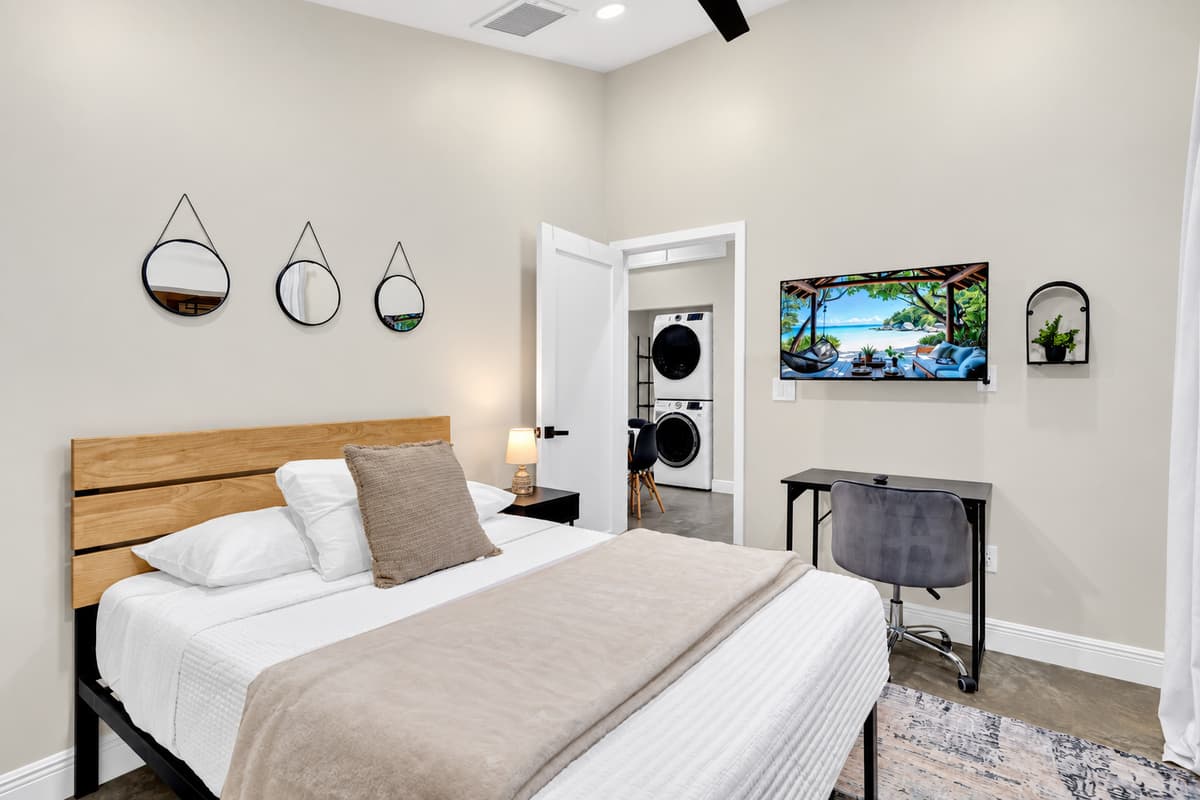 Bright, calm, and completely your own. Comfortable bed against a warm wood headboard, smart TV on the wall and a desk by the window. Close the door and the rest of the house stops existing.