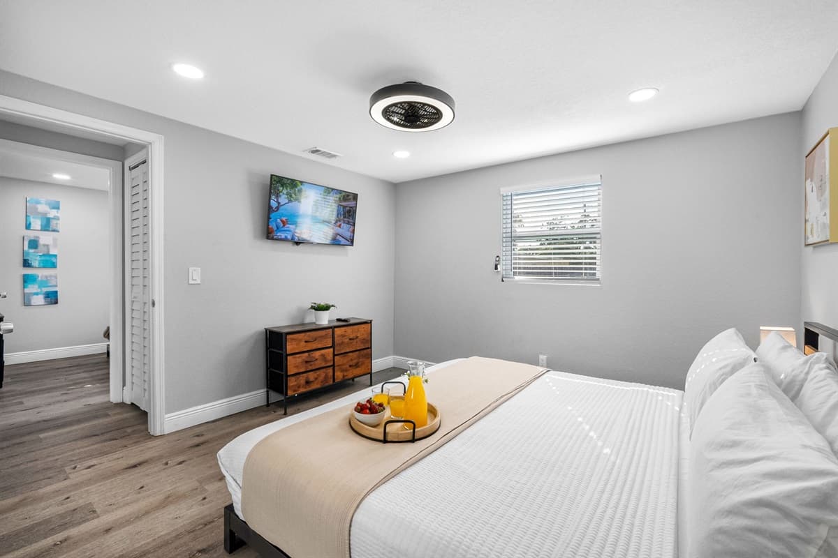 Rest easy in this bright and airy bedroom featuring soft lighting, a comfy mattress, and tranquil decor.