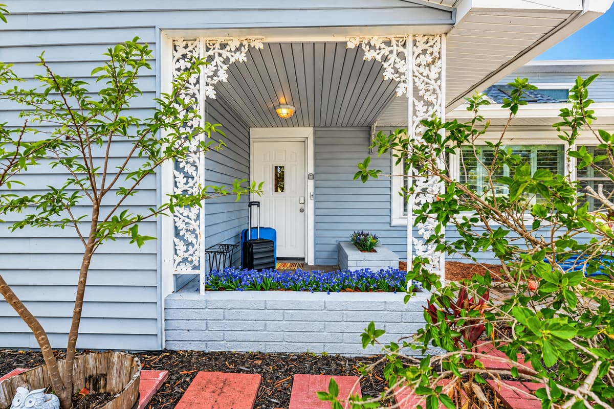 Charming front entrance with greenery and thoughtful landscaping—welcoming you to your stay 