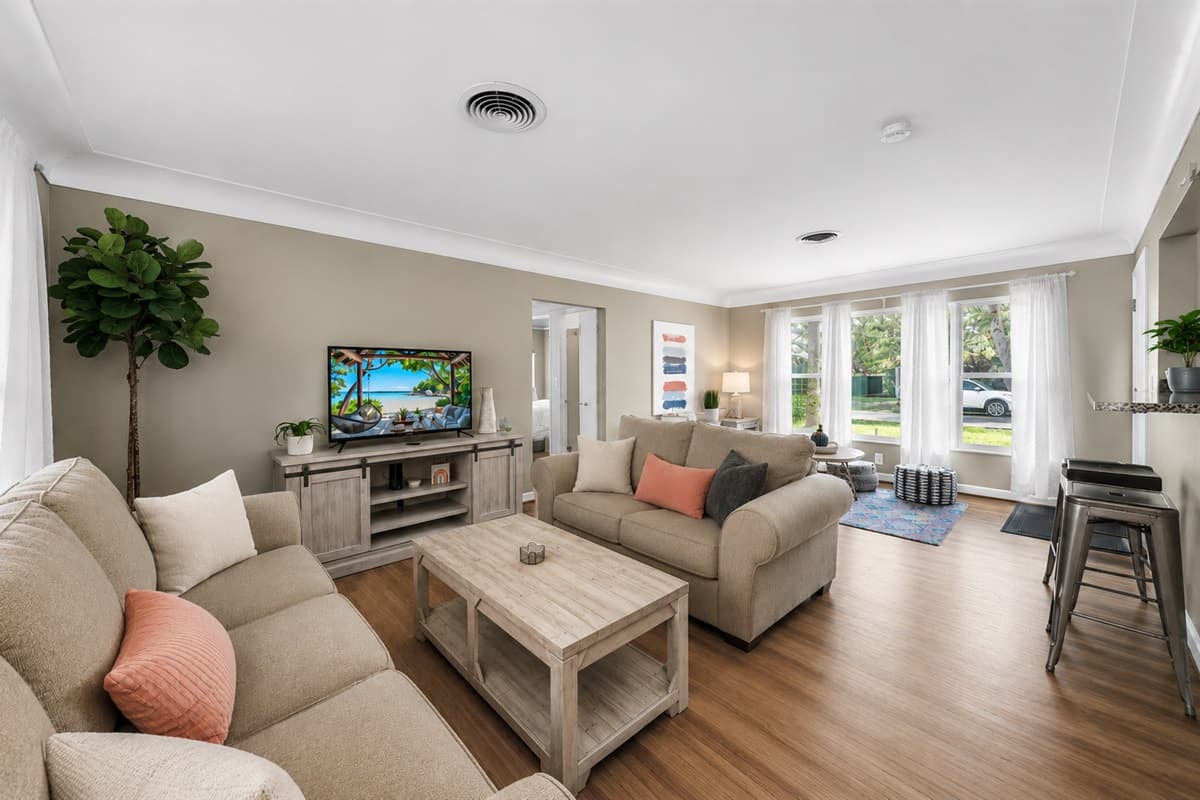 Wide living room view showcasing ample seating and an airy, open layout perfect for gatherings.