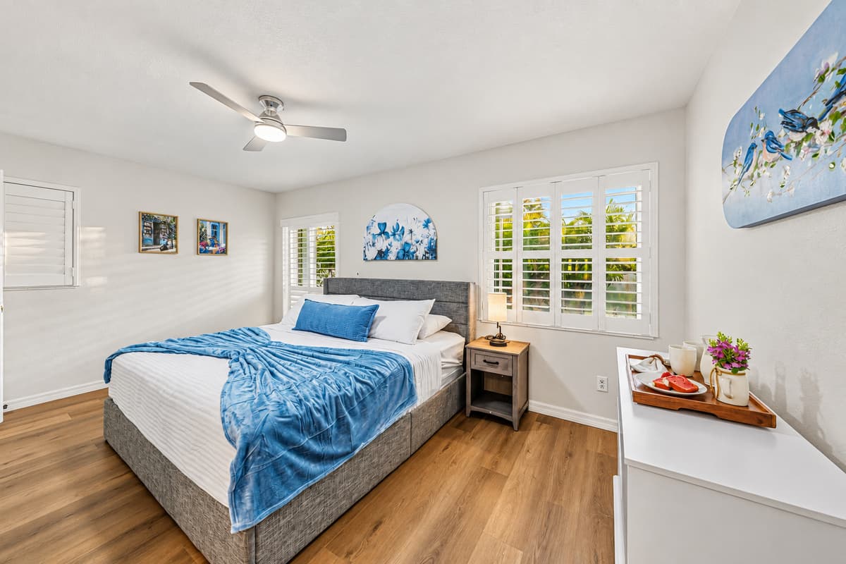 Bright and cozy bedroom featuring a king-size bed, natural light, and clean, modern décor 