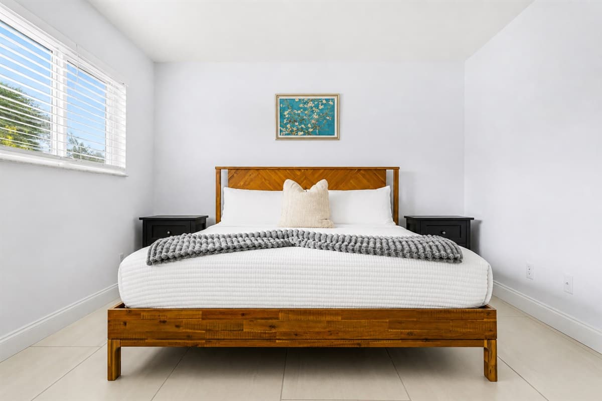 Clean and modern bedroom with plush bedding and bright open layout.