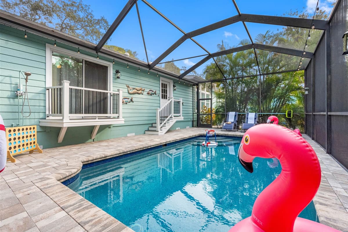 A peaceful backyard escape with a sparkling pool, tall greenery for privacy, and plenty of space for unwinding in the sun.