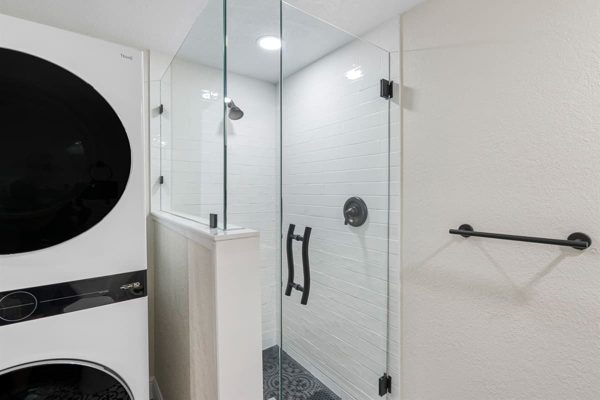 The sleek, frameless glass shower enclosure adds a modern touch while keeping the space open and airy.