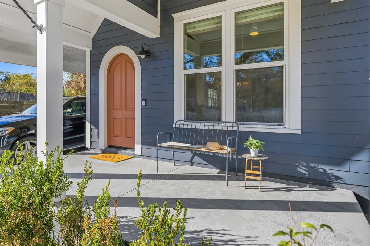 Step onto the inviting covered front porch of this brand-new Seminole Heights home. The signature arched terracotta door, oversized modern windows, and lush tropical plants create a warm, stylish welcome you won't forget.