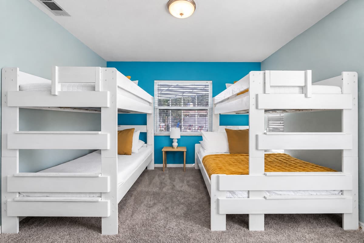 A vibrant space featuring two bunk beds, comfy bedding, and plenty of natural light — ideal for family stays.