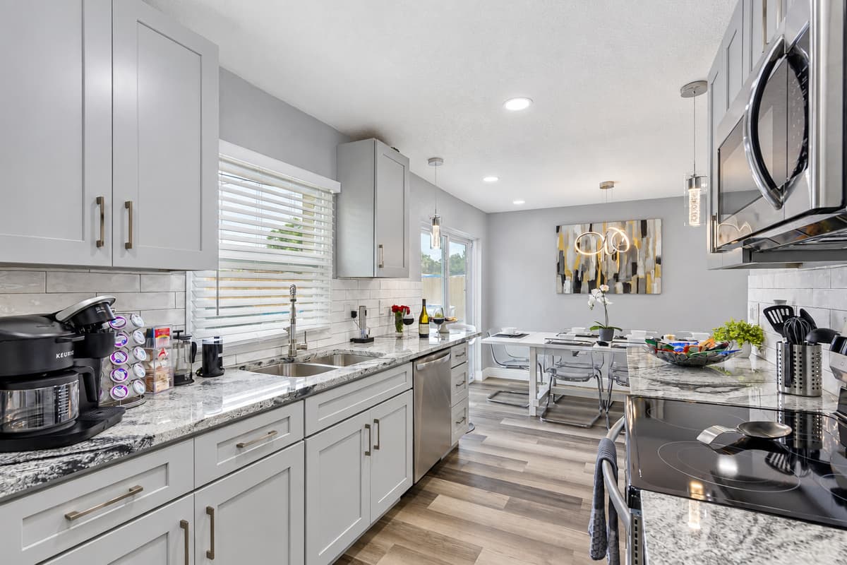 Open kitchen, open conversation. The kitchen flows into the dining room and living area. Whoever's cooking stays part of the fun, never closed off in another room.