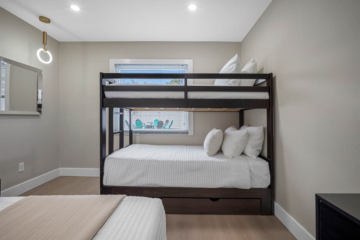 Natural light fills this modern bedroom, offering cozy bedding and a clean, contemporary design — perfect for kids, teens, or additional guests.