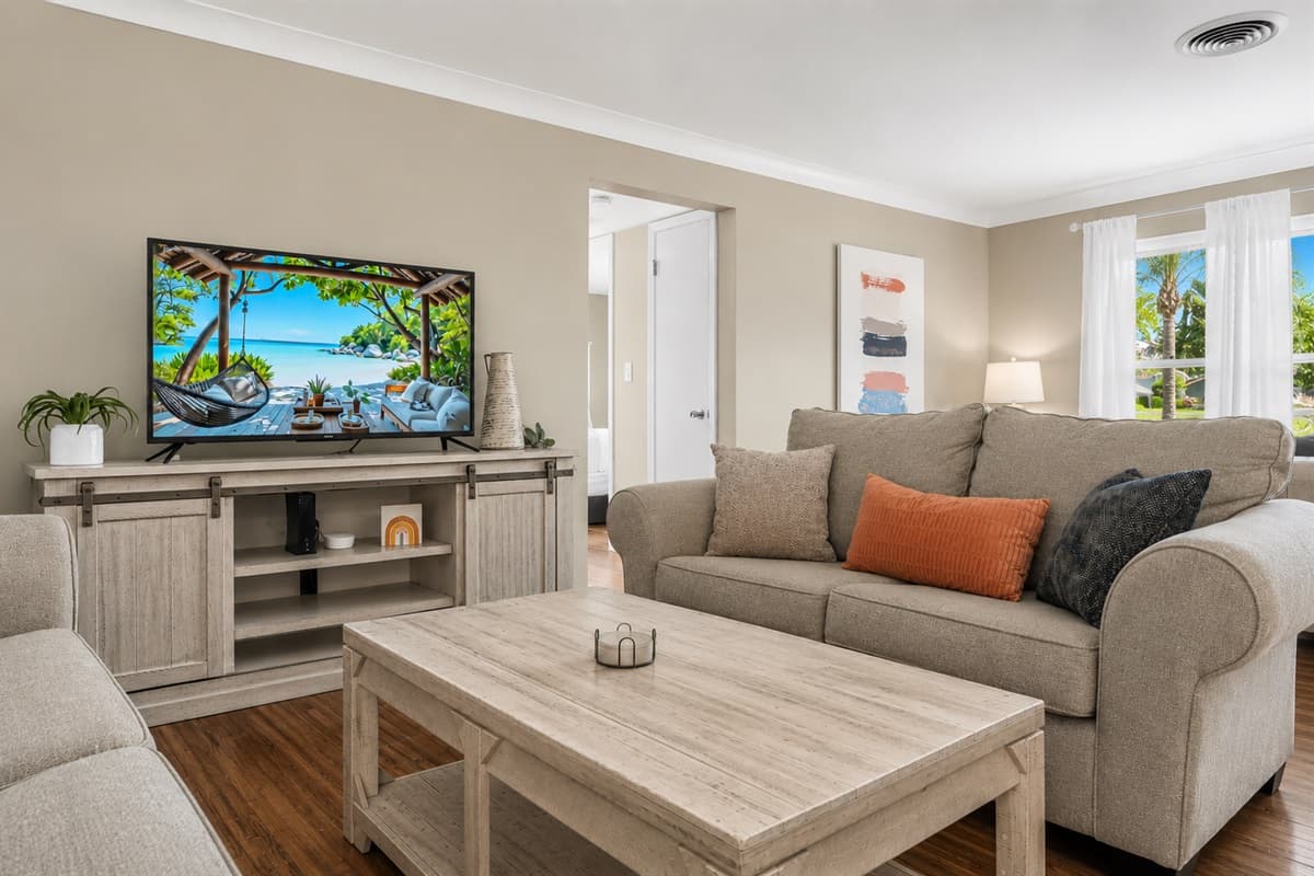 Comfortable entertainment area with a large TV, plush seating, and relaxing coastal-inspired décor.