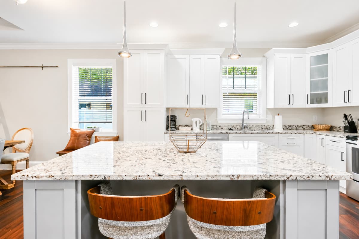 Prepare your favorite meals in the fully equipped kitchen featuring granite countertops, stainless steel appliances, and a large island with seating.