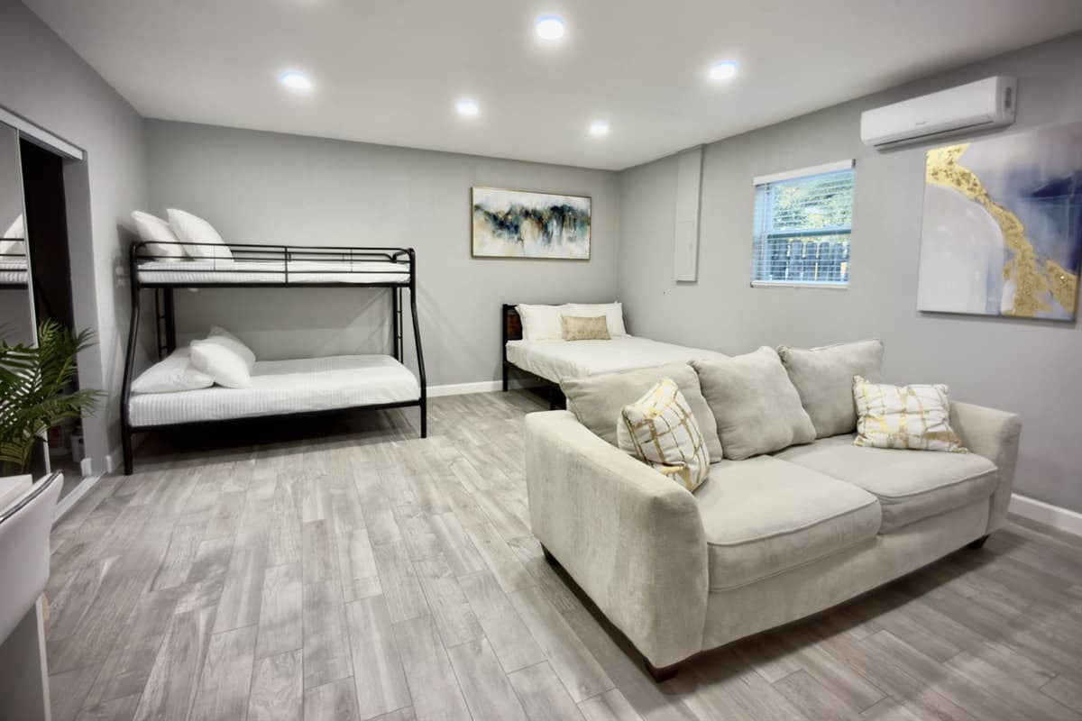 This beautifully appointed bedroom boasts a queen-size bed, a bunk bed, and a comfortable seating area, creating a warm and welcoming atmosphere.