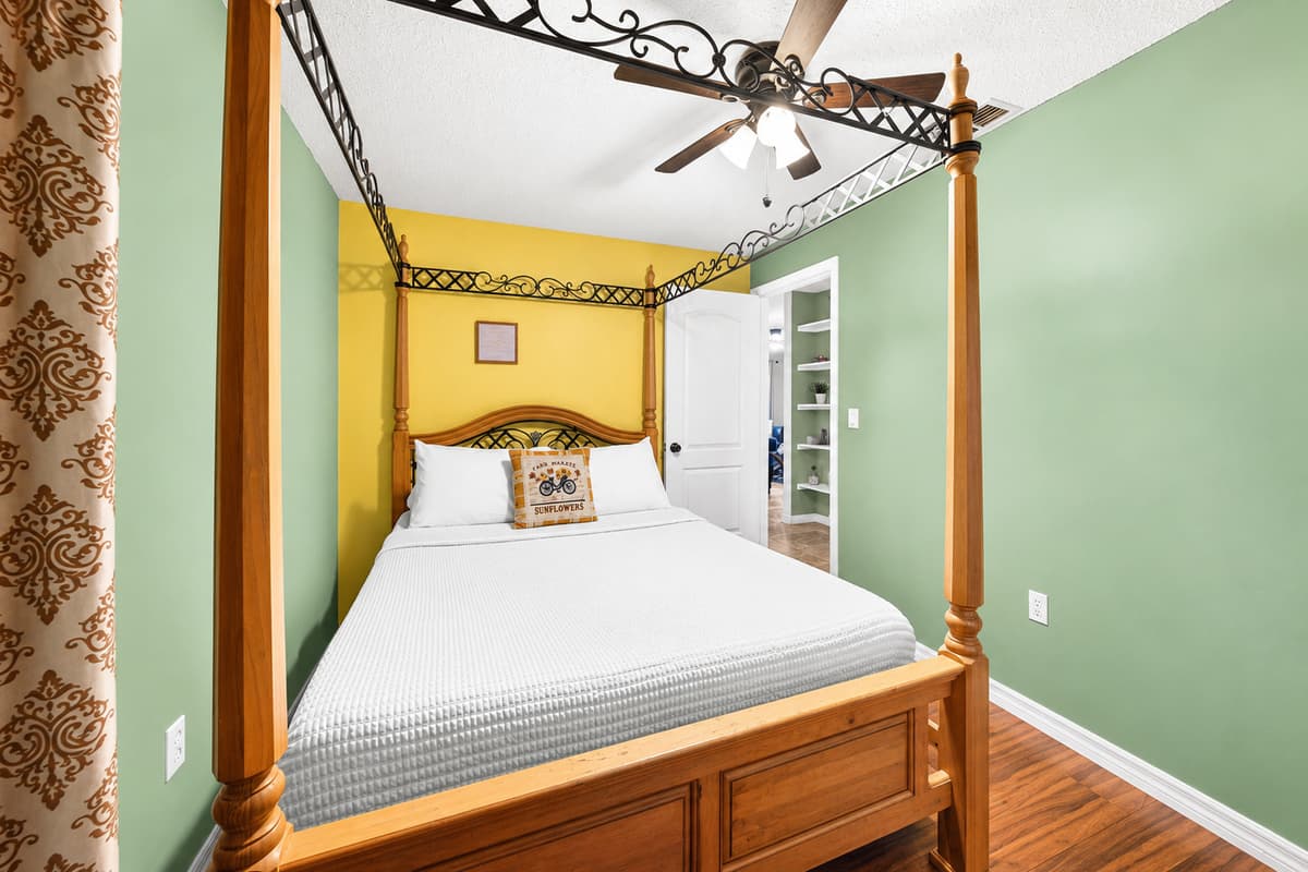 Cozy bedroom featuring a beautiful queen-size canopy bed and warm, inviting décor.