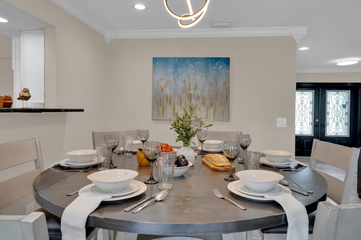 A round dining table set with care shows exactly how easy it is to gather the whole group for dinner together