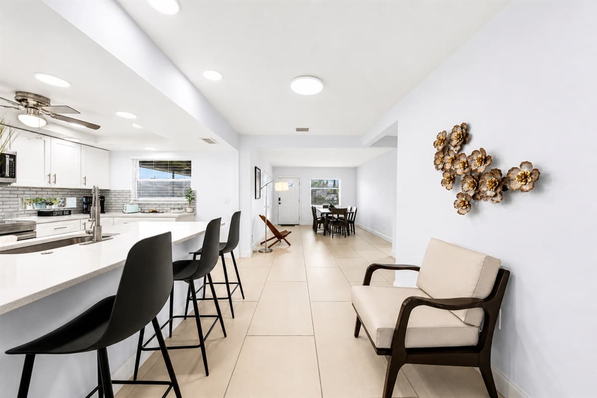 Wide-angle kitchen view showcasing the open-concept layout and comfortable breakfast bar seating.