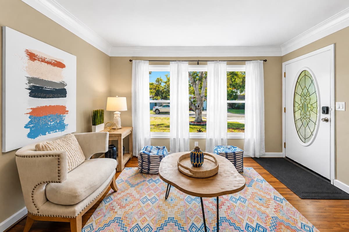 Bright front sitting area with large windows, cozy seating, and welcoming natural light.