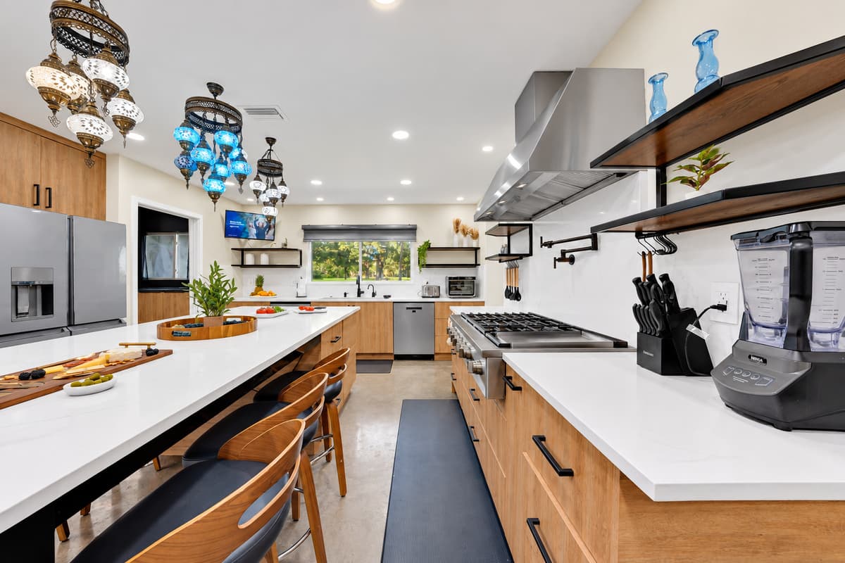 The kitchen that actually feeds eighteen people. Professional-style range, double islands and counter space on every side — cook a real dinner for the whole group without anyone in your way.