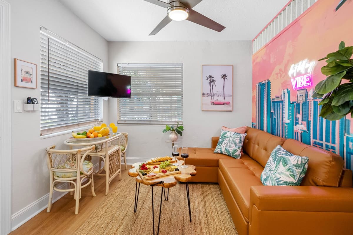 Artful décor, including abstract paintings, palm leaf accents, and sculptural elements, further embodies Miami’s dynamic art and design scene.