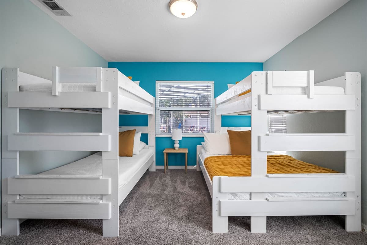 A vibrant space featuring two bunk beds, comfy bedding, and plenty of natural light — ideal for family stays.