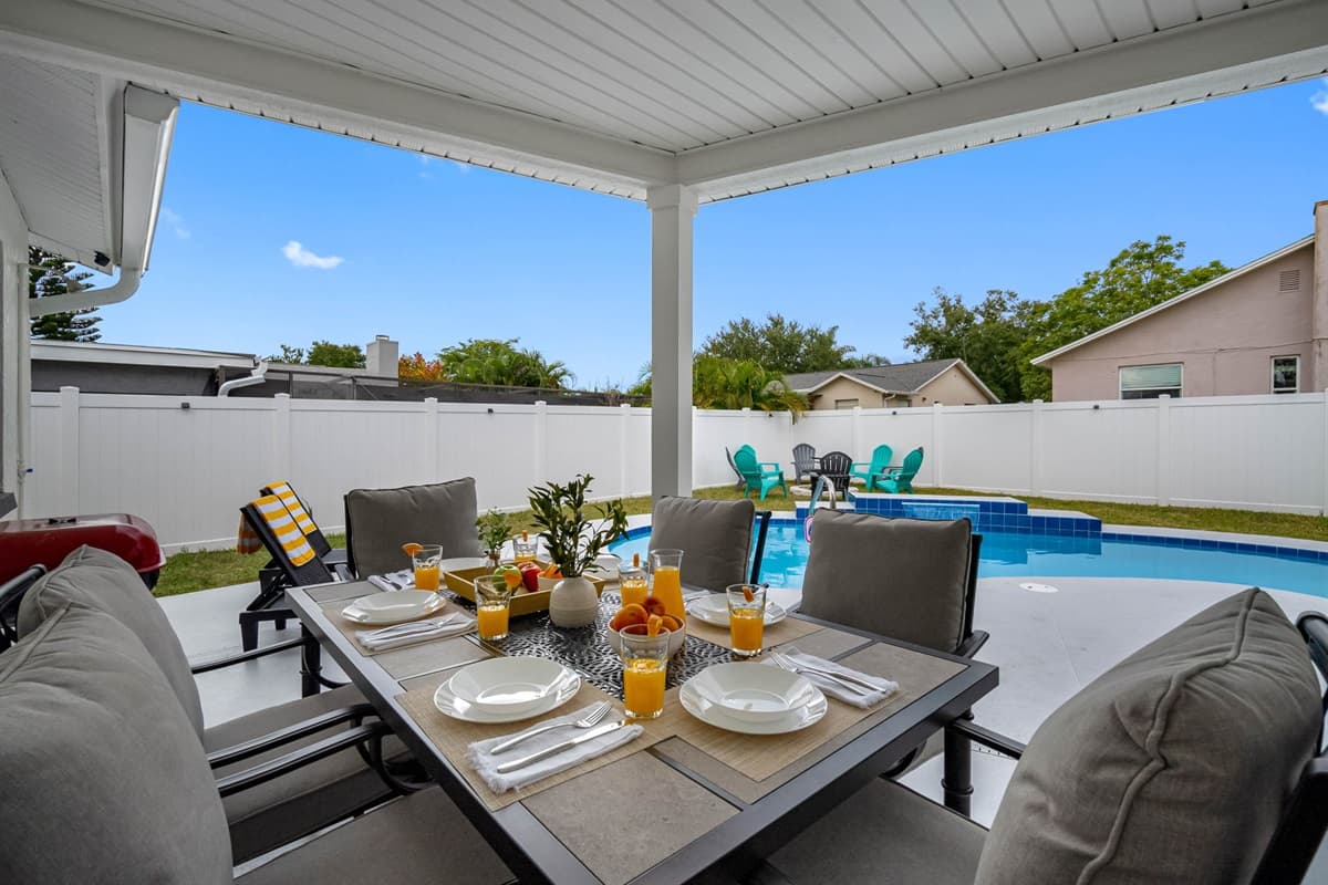 Enjoy Florida living at its best with this breezy covered patio. The dining table, cozy lounge seating, and poolside views make it the perfect place to relax all day long.
